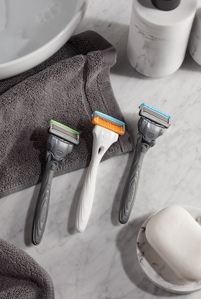 Three razors against marble counter with grey towel