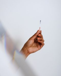 Hand holding an OVRY pregnancy test against a white background