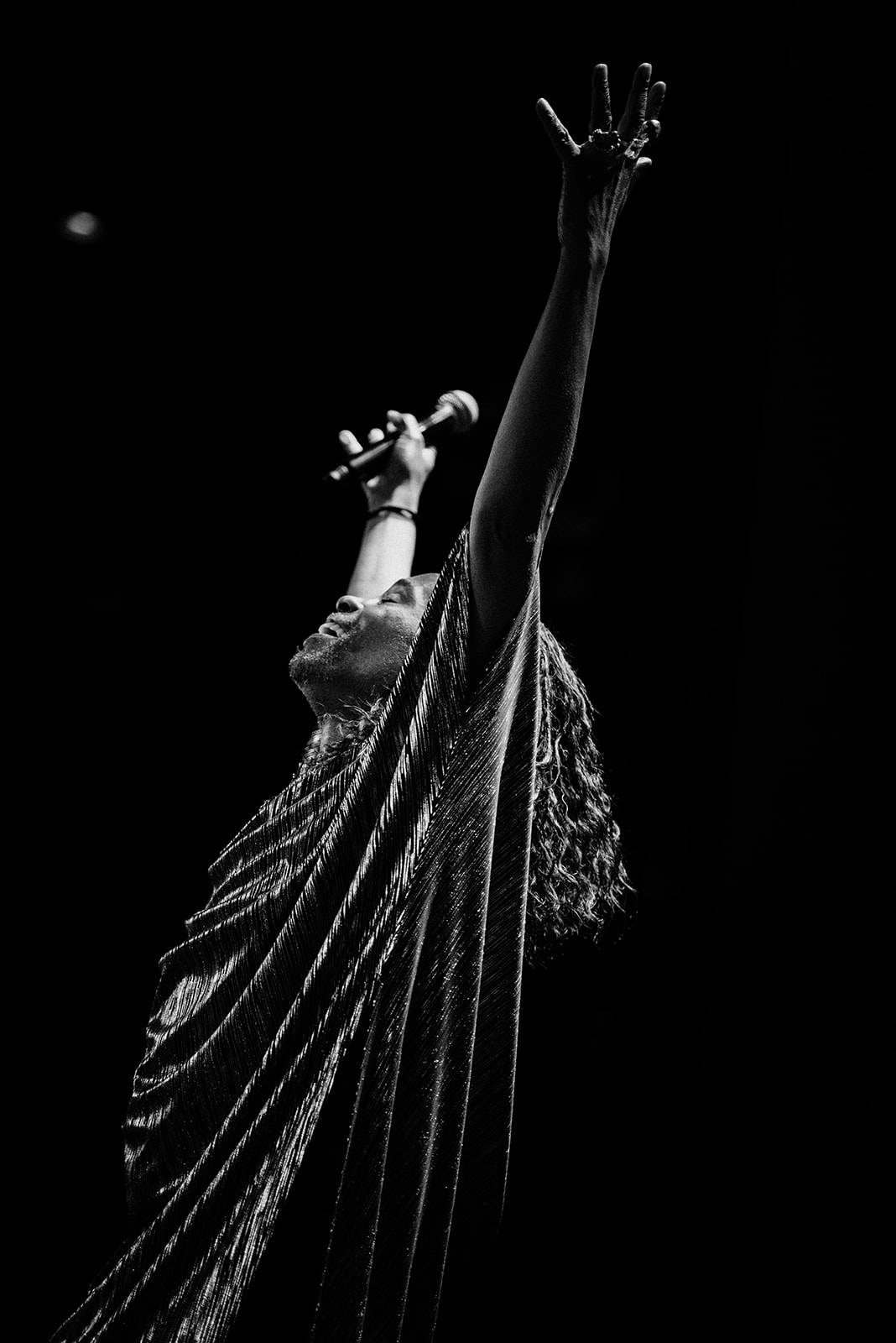 BLack and white photo of Billy Porter with his hands raised.