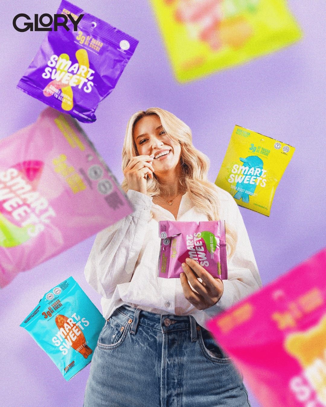 Tara Bosch holding a pack of SmartSweets eating a candy with others in the air.