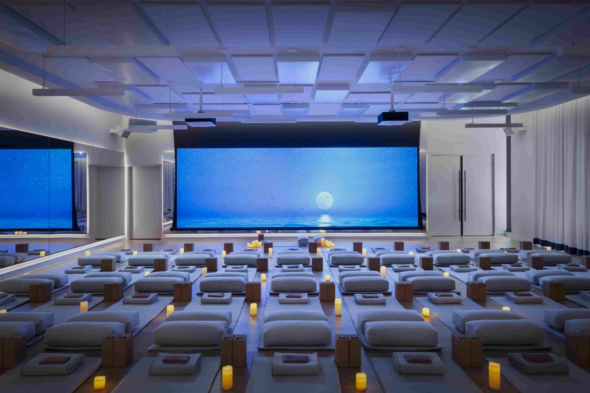 Serene pilates room in a theatre style with a large screen.