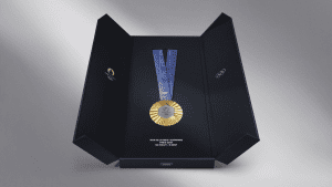 A trophy case that is opened and revealing the Olympic gold medal with a blue satin ribbon.