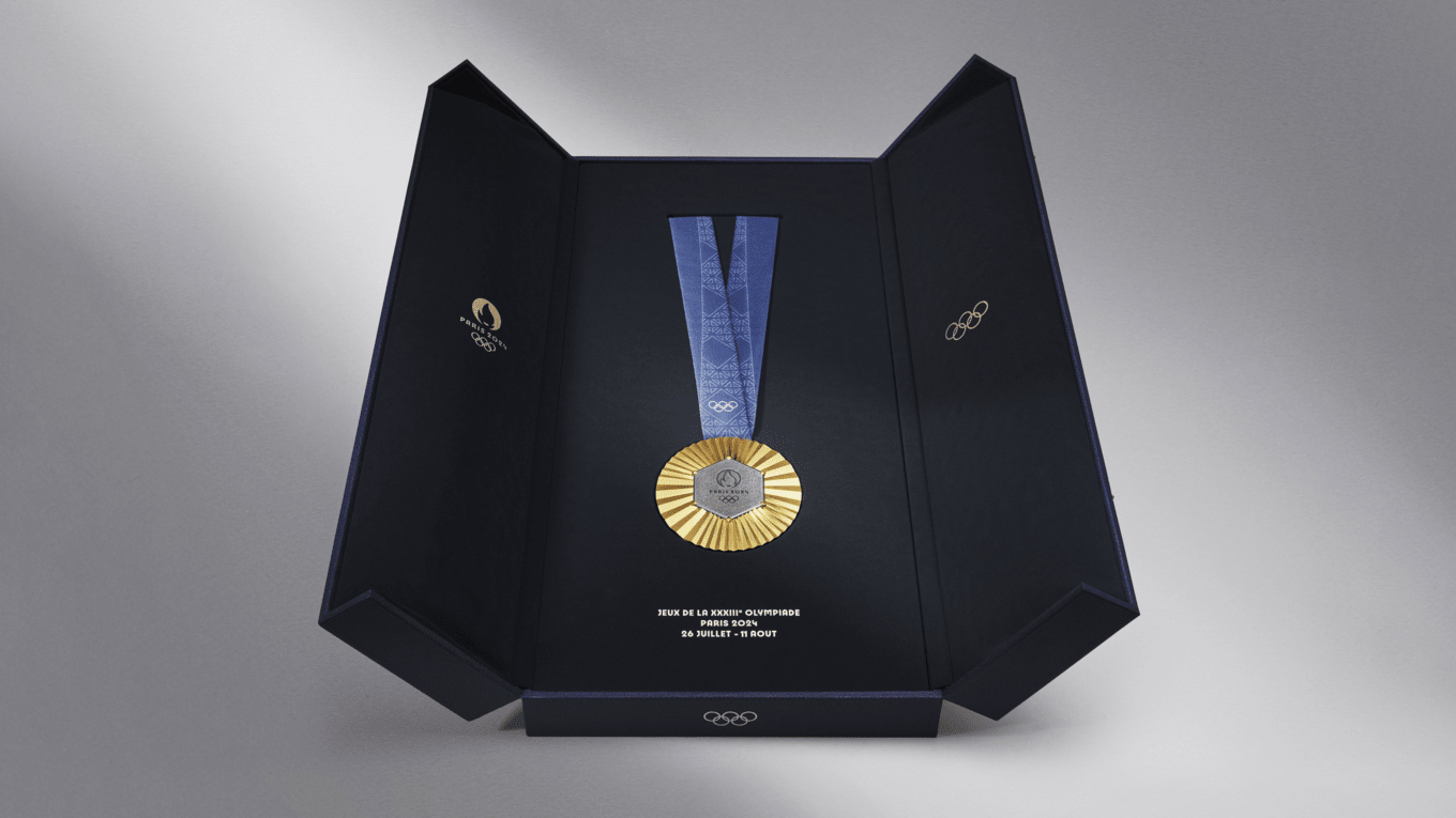 A trophy case that is opened and revealing the Olympic gold medal with a blue satin ribbon.