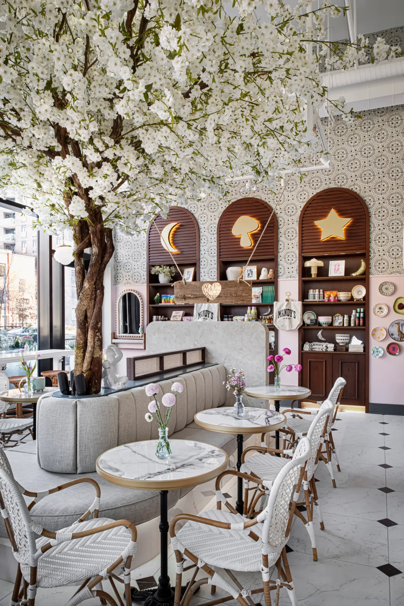 Restaurant interior with a tree and white, airy aesthetic.