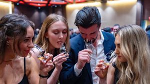 Whisky Global gathering of people sniffing from a whisky snifter.