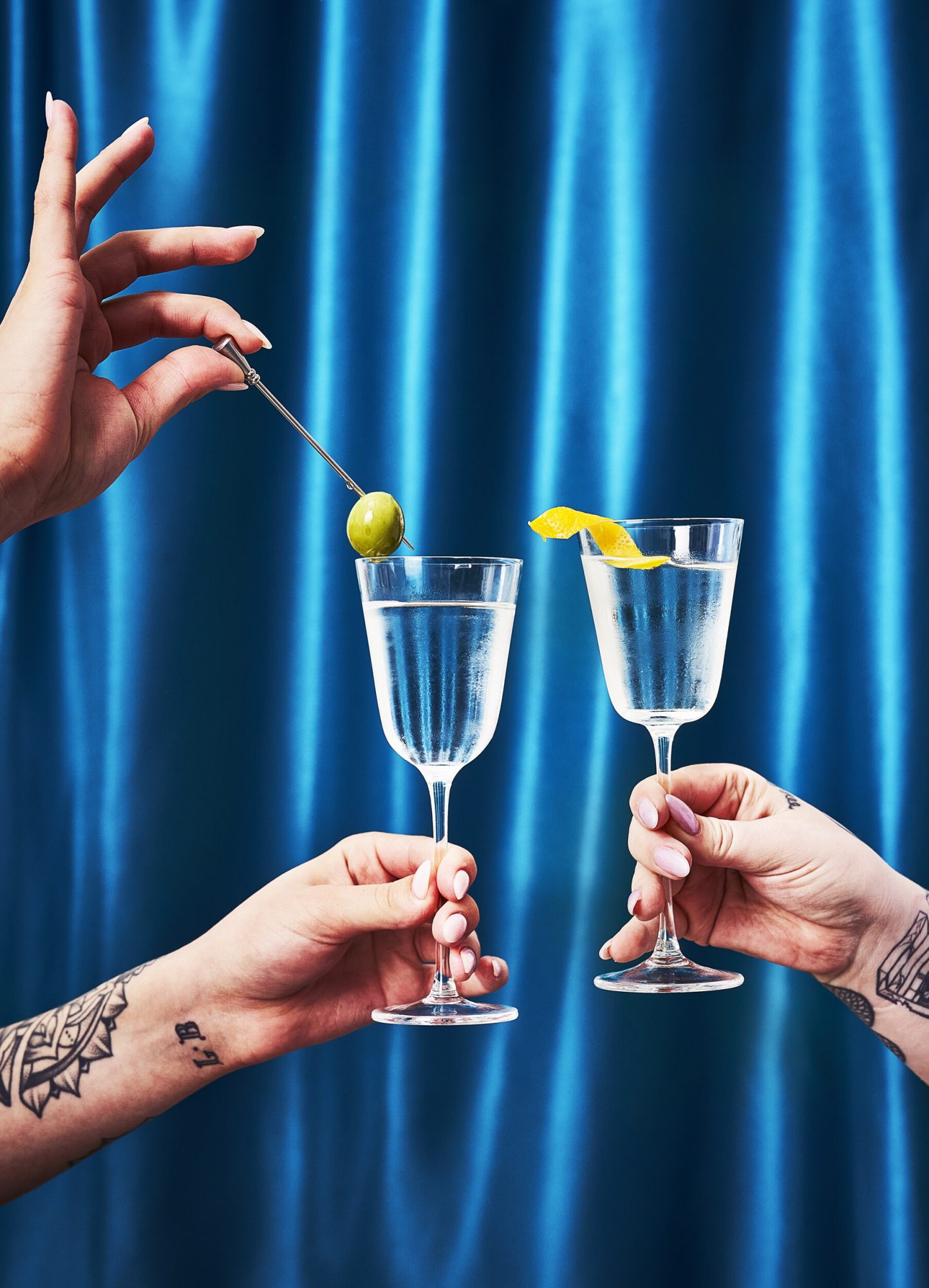 Pair of martini glasses against a blue curtain